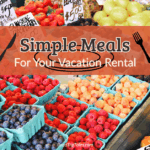 Farm stand with fresh berries and fruit in teal cartons, overlaid with text reading “Simple Vacation Rental Meals.”